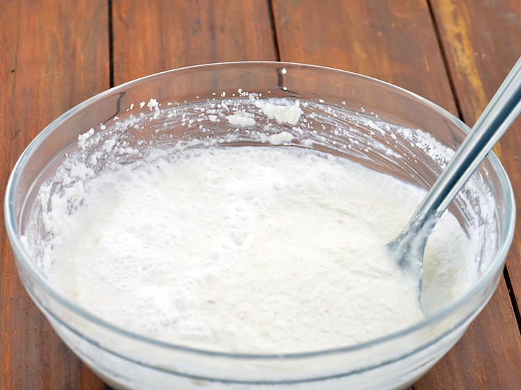 Step 6 – <p>ફ્રૂટ સોલ્ટ અને 1/2 કપ પાણી ઉમેરો અને ધીમેધીમે ભેળવીને ઇડલી બેટરની સુસંગતતા બનાવો. જો …