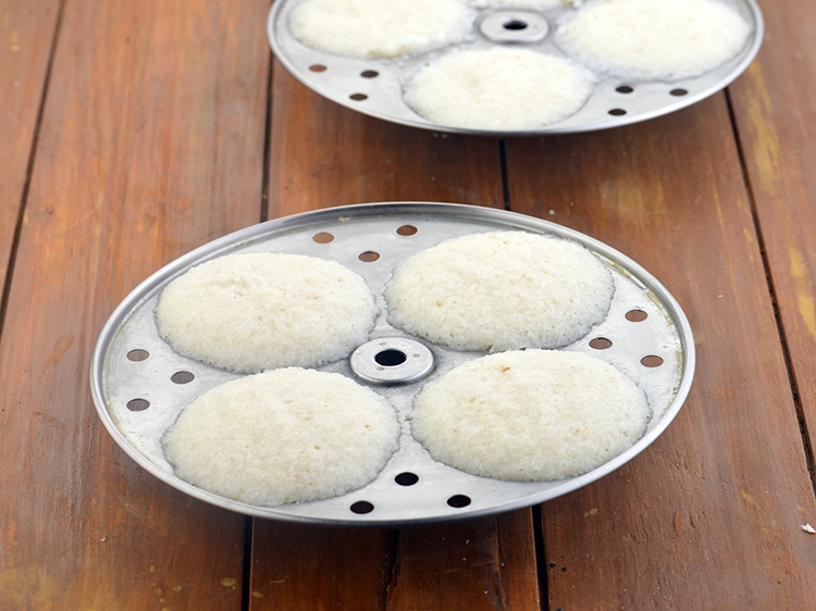 Step 9 – <p>ચમચીનો ઉપયોગ કરીને, ઇડલીને થોડી ઠંડી કરો.</p>