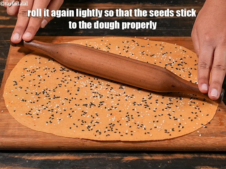 Step 21 – <p>તેને ફરીથી હળવાશથી રોલ કરો જેથી બીજ કણક સાથે યોગ્ય રીતે ચોંટી જાય.</p>