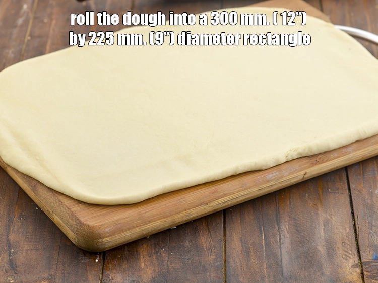 Step 23 – <p>કણકને રોલિંગ બોર્ડ પર મૂકો. કણકને 300 મીમી (12”) બાય 225 મીમી (9”) વ્યાસના લંબચોરસમાં …