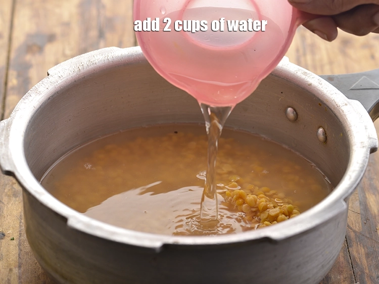 Step 10 – <p>પ્રેશર કૂકરમાં 2 કપ પાણી ઉમેરો.</p>