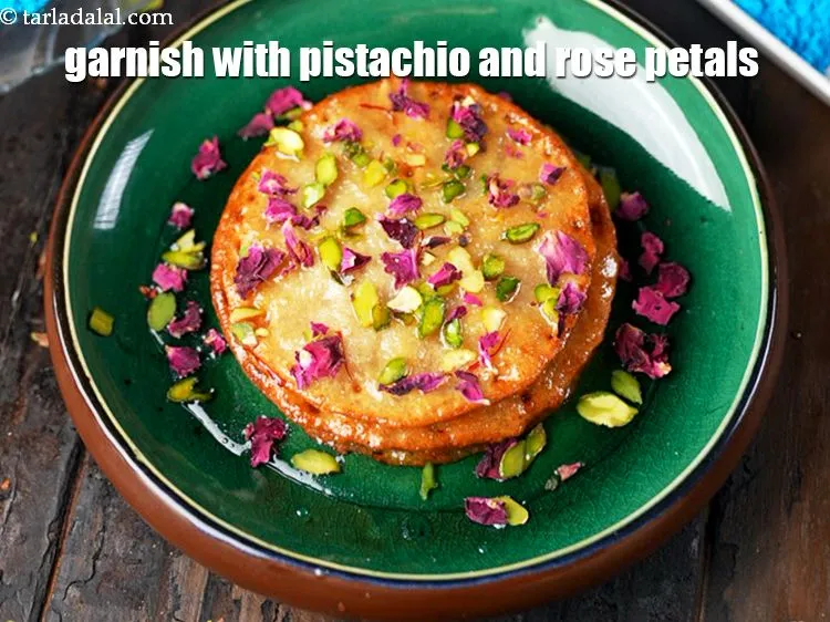 Step 20 – <p><a href="https://www.tarladalal.com/glossary-pistachios-pista-gujarati-891i#ing_3237"><u>પિસ્તાની કાતરી (pistachio slivers)&nbsp;</u></a> અને <a href="https://www.tarladalal.com/glossary-rose-petals-gulab-ke-patte-gujarati-665i#ing_3467"><u>ગુલાબની સૂકી પાંખડીઓ&nbsp;</u></a>થી સજાવો. માલપુઆને તરત જ પીરસો.</p>