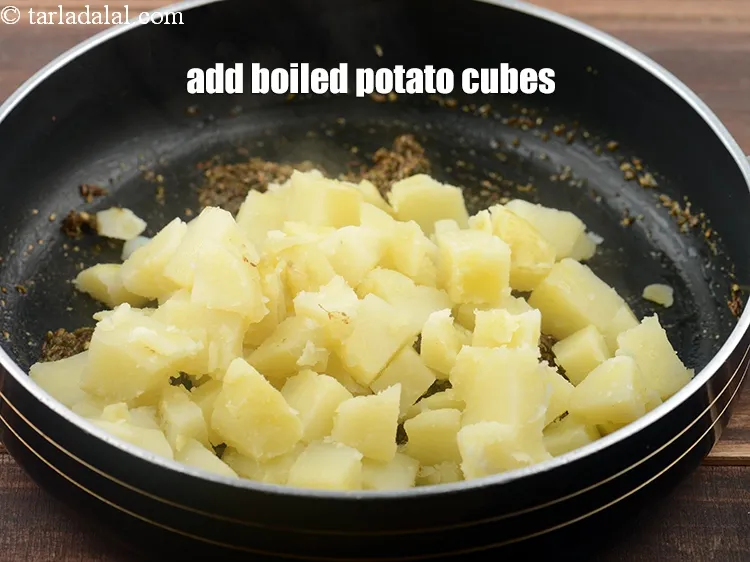 Step 23 – <p><span style="background-color:rgb(255,255,255);color:rgb(0,0,0);">2 1/2 કપ </span><a href="https://www.tarladalal.com/glossary-potatoes-aloo-alu-batata-gujarati-710i#ing_2605"><u>બાફેલા બટાટાના ટુકડા (boiled potato cubes)</u></a> ઉમેરો.</p>