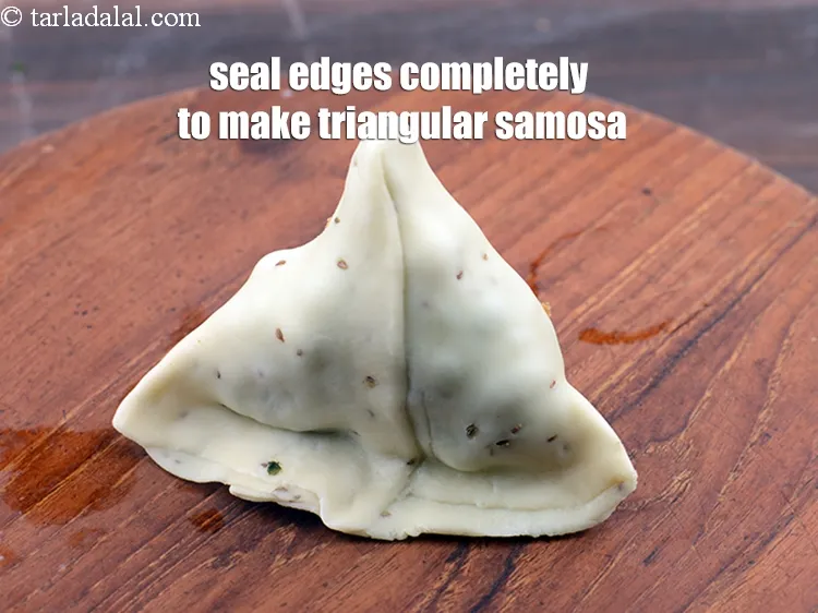 Step 41 – <p>તેને સીલ કરવા માટે કિનારીઓને એકસાથે ચપટી કરો. થોડું વધુ પાણી વાપરીને સંપૂર્ણ ત્રિકોણાકાર પંજાબી …