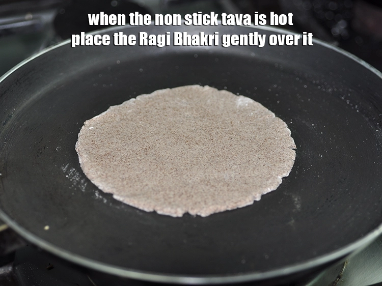 Step 11 – <p>જ્યારે નોન-સ્ટીક તવા ગરમ હોય ત્યારે રાગી ભાખરીને તેના પર હળવેથી મૂકો. જો તવા ગરમ …