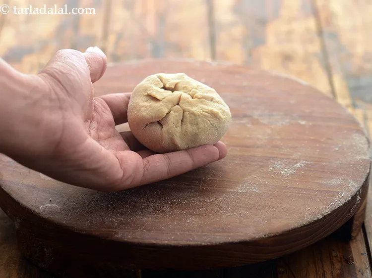 Step 21 – <p>બાજુઓને મધ્યમાં ખેંચવાનું શરૂ કરો. બધી બાજુઓને મધ્યમાં ખેંચ્યા પછી, વધારાનો લોટ ખેંચો. ચુસ્તપણે સીલ …