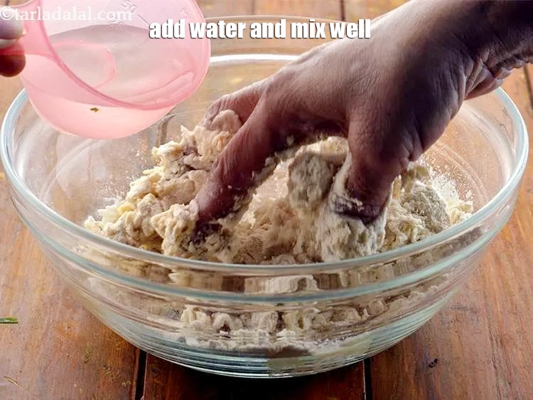 Step 4 – <p>ધીમે ધીમે કણક બનાવવા માટે પાણી ઉમેરો. પાણીની માત્રા લોટની ગુણવત્તા પર આધાર રાખે છે. …