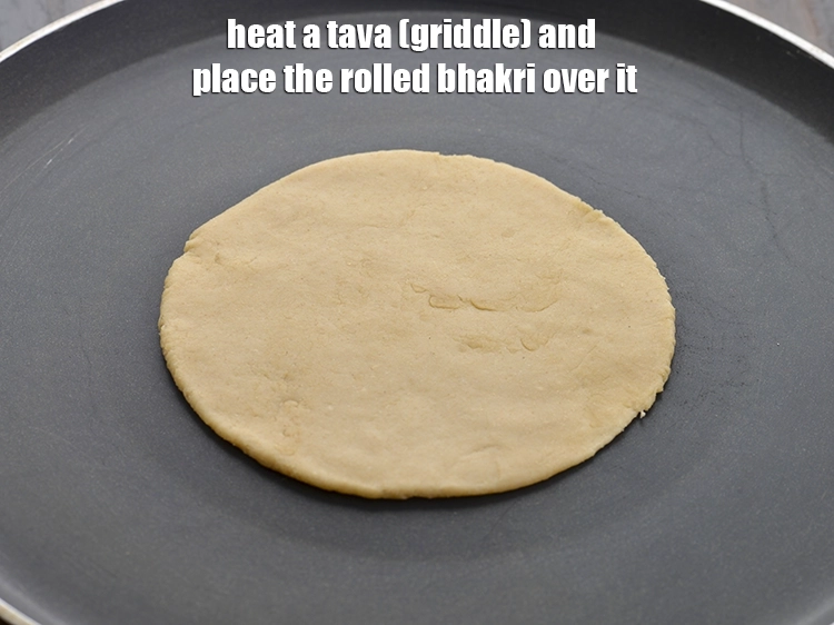 Step 12 – <p><span style="background-color:rgb(255,255,255);color:rgb(0,0,0);">તવાને ગરમ કરો અને તેના પર ગોળ ભાખરી મૂકો. પરંપરાગત રીતે, ભાખરી માટીના તવા …