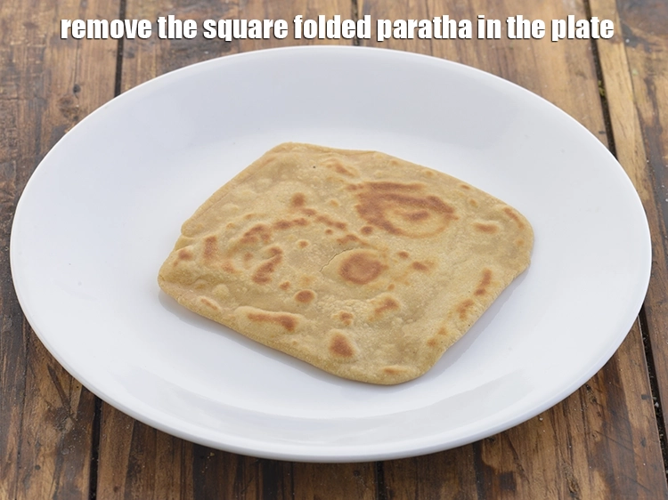 Step 48 – <p>ચોરસ ફોલ્ડ કરેલા પરાઠાને પ્લેટમાં કાઢી લો.</p>