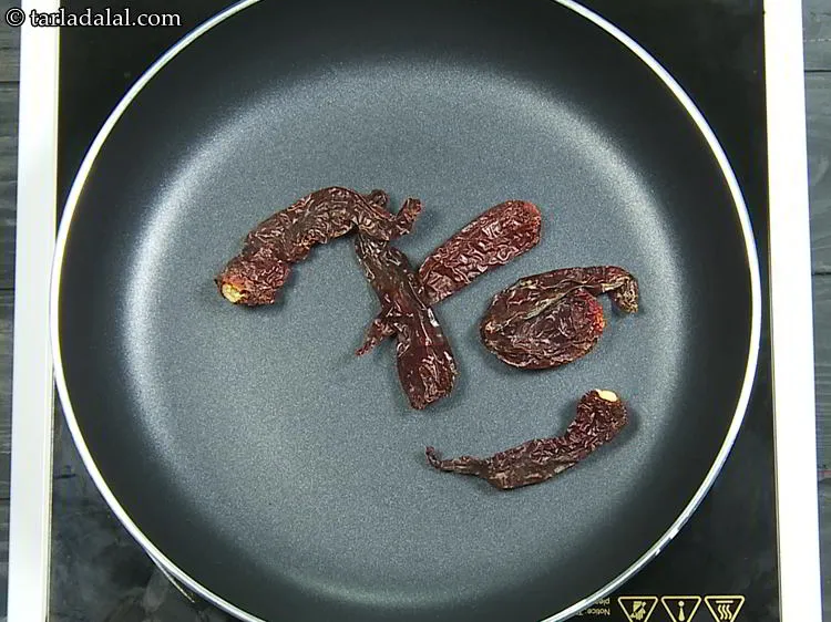 Step 3 – <p>બધી સામગ્રીને એક પહોળા નોન-સ્ટીક પેનમાં નાખો, શરૂઆત કાશ્મીરી લાલ મરચાથી કરો. દાંડી કાઢી નાખવામાં …