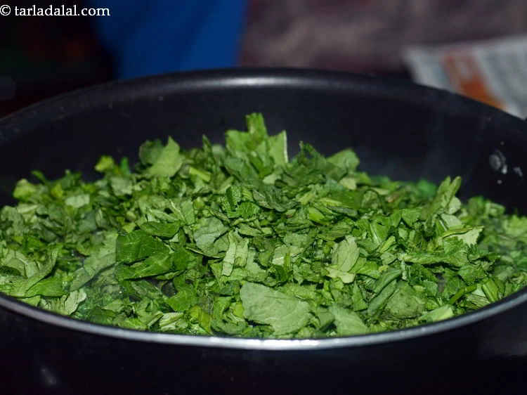 Step 6 – <p>સરસોં ના પાન ઉમેરો. પરંપરાગત રીતે રાંધેલા સરસોં ના સાગમાં બથુઆ સાગ (હંસફૂટ, ચેનોપોડિયમ) અને …