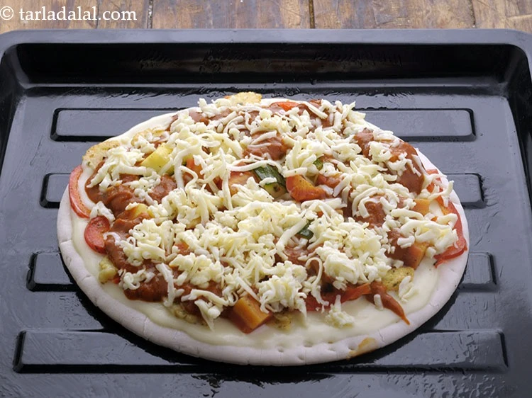 Step 26 – <p>બંને પિઝાને ગ્રીસ કરેલી બેકિંગ ટ્રે પર મૂકો.</p>