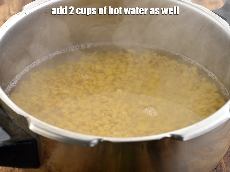 स्टेप 21 – <p>साथ ही २ कप गरम पानी डालें।</p>