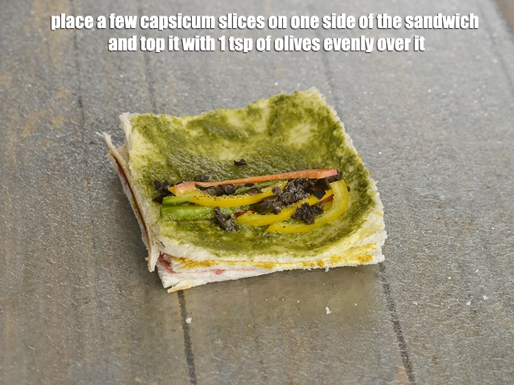 स्टेप 7 – <p>सैंडविच के एक तरफ कुछ <a href="https://www.tarladalal.com/glossary-capsicum-shimla-mirch-bell-pepper-hindi-163i#ing_2312"><u>स्लाईस्ड शिमला मिर्च (sliced …