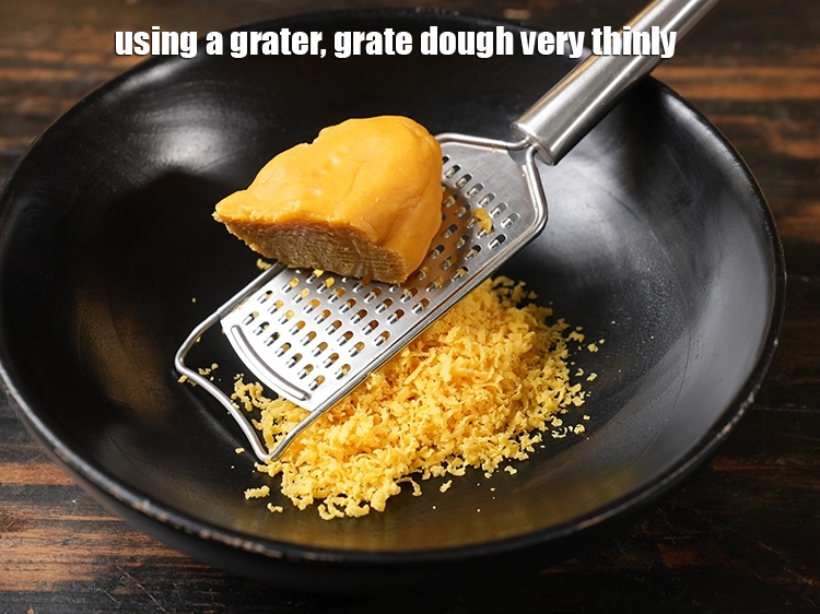 स्टेप 9 – <p>एक ग्रेटर का प्रयोग करके, आटे को बहुत पतला कद्दूकस …