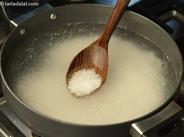 स्टेप 6 – <p>उबलते पानी में चावल डालें। चावल को लगभग अल डांटे …