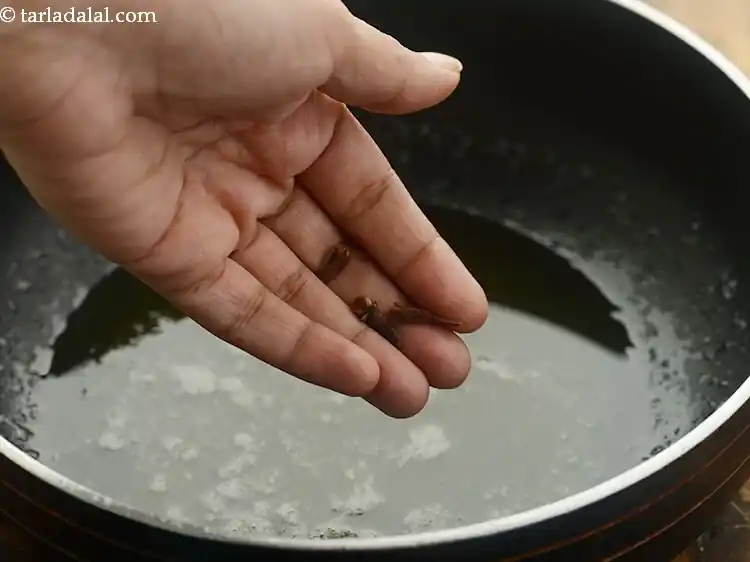 स्टेप 34 – <p>जब घी गरम हो जाए, तो उसमें लौंग डालें।</p>