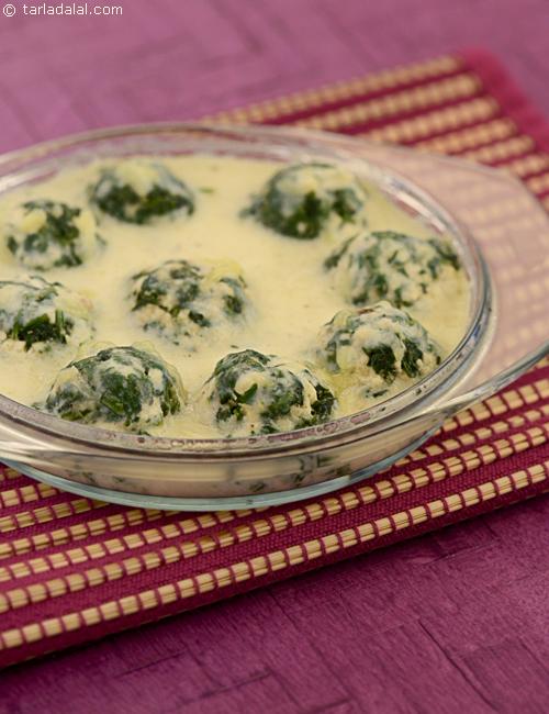 Steamed spinach and paneer dumplings baked with white sauce and cheese.