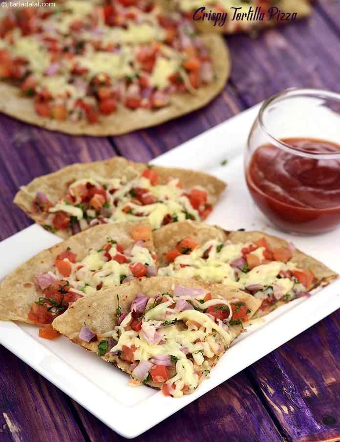 Crisped chapatis topped with tomatoes, onions and loads of cheese, the crispy tortilla pizza is a wonderful after-school treat for your kids.