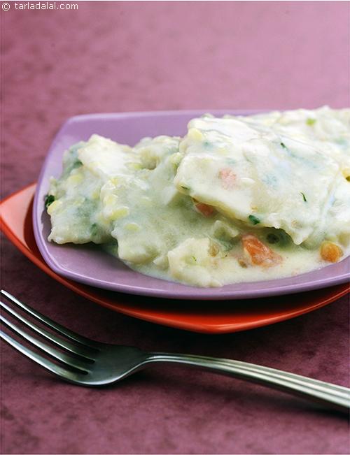 Garlic Basil Ravioli with Alfredo Sauce, refreshing green garlic and basil flavoured pasta dough is filled with tomatoes and tossed with Alfredo sauce. You can also serve this ravioli tossed in butter and topped with parmesan cheese.