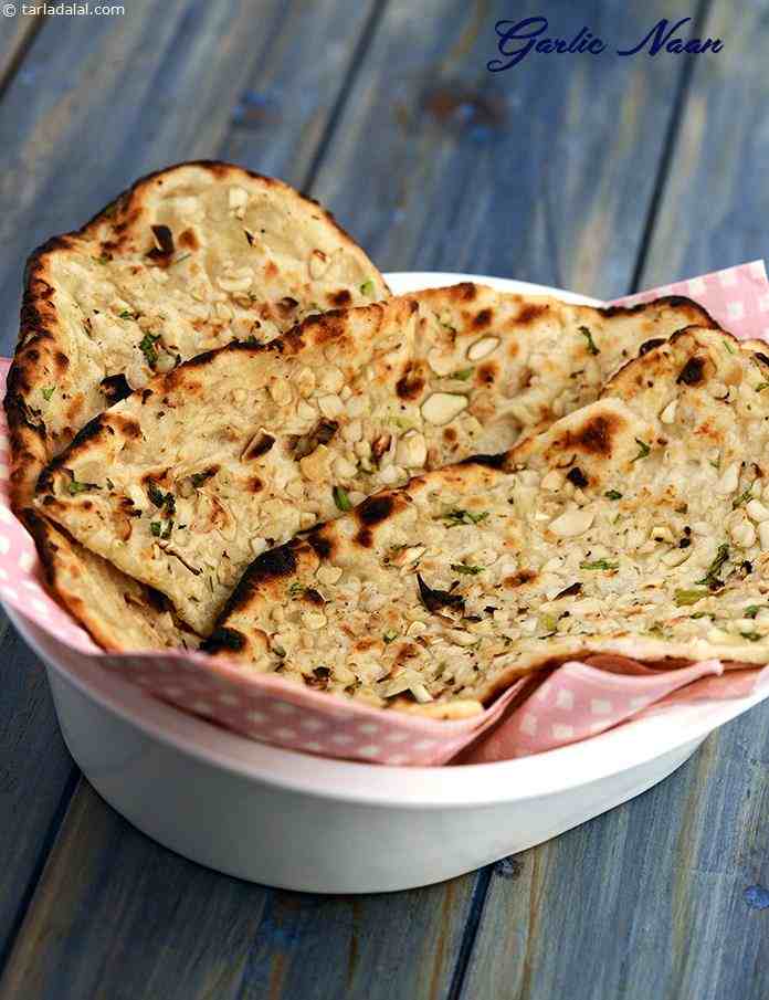 Garlic Naan, exquisitely flavoured leavened bread cooked in a tandoor! i have added some garlic cloves to the naan dough to enhance its flavour. 