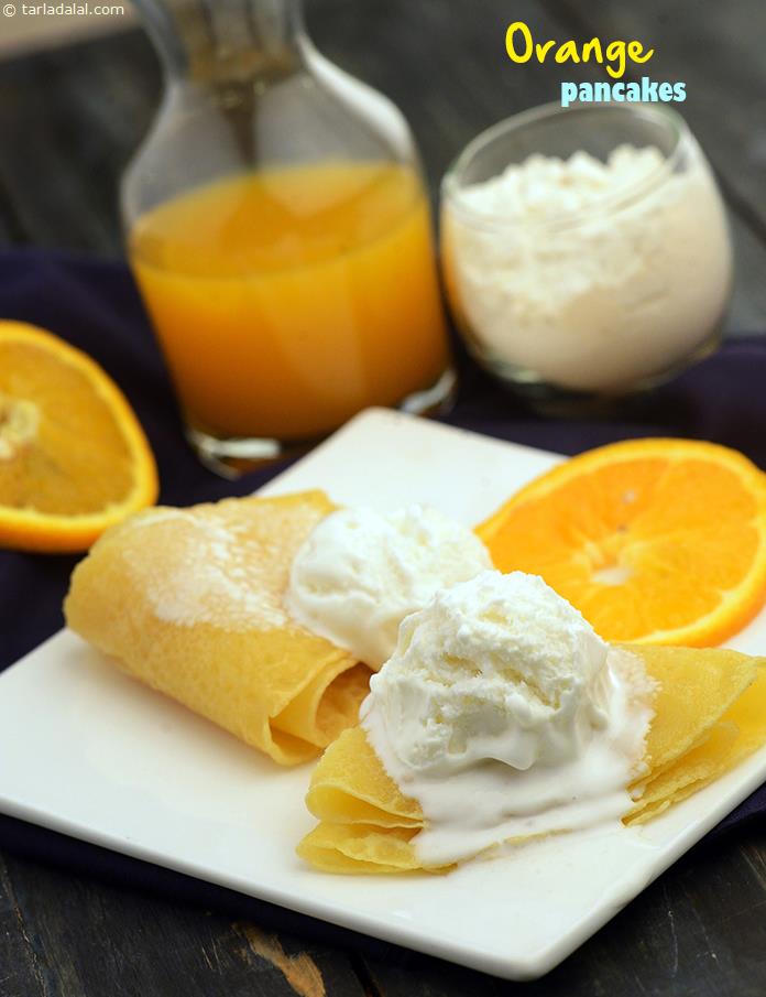 Orange Panckes, these delicious butter-cooked orange-flavoured pancakes are folded into triangles and topped with vanilla ice-cream. You could make the Orange Pancakes more special by adding garnishes of your choice.