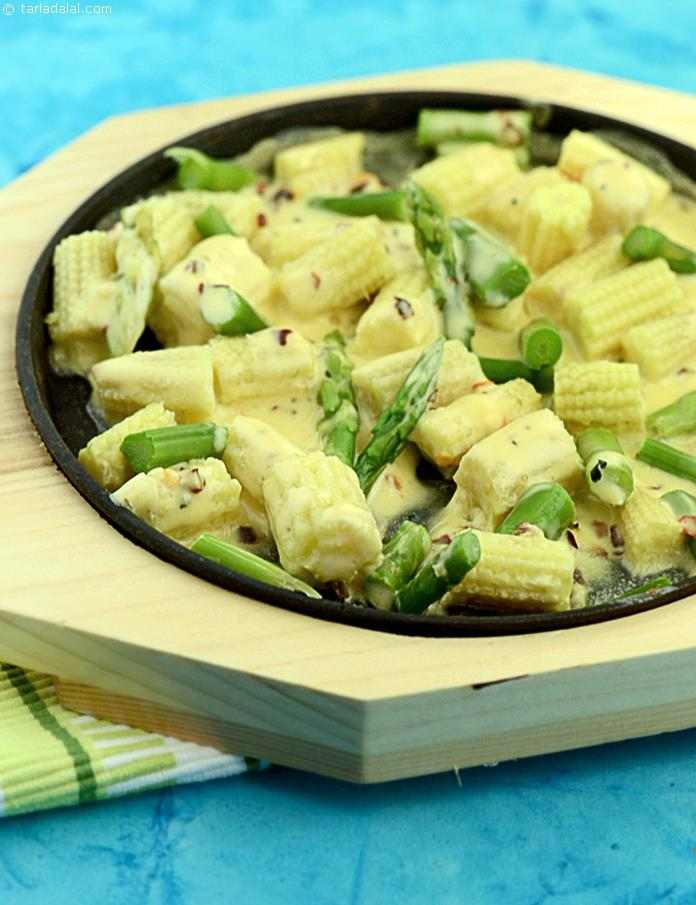 Sizzling Asparagus and Baby Corn served on a hot sizzler plate with oregano, garlic and paprika flavoured cheese sauce.