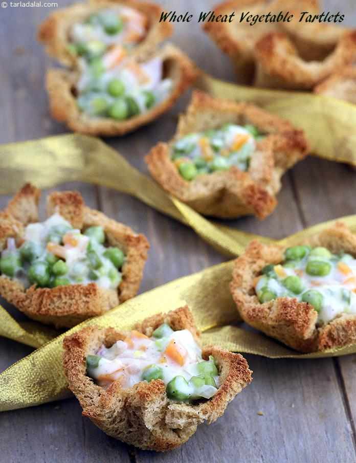 A scrumptious snack of whole wheat tartlets packed with assorted veggies. The stuffing is held together by a unique white sauce that is thickened with whole wheat flour and low-cal milk. 